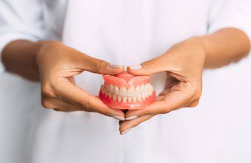 Lady presents viewer with dentures