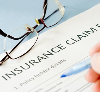 Person holding pain, preparing to fill out dental insurance claim form