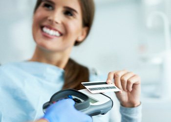 A woman paying for cosmetic dentistry