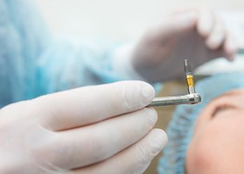 dentist performing dental implant surgery