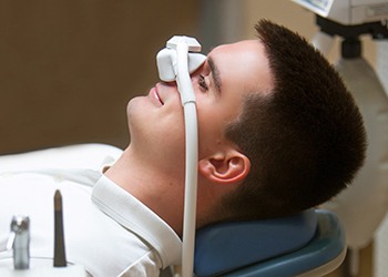 Patient relaxing while breathing in nitrous oxide in treatment chair