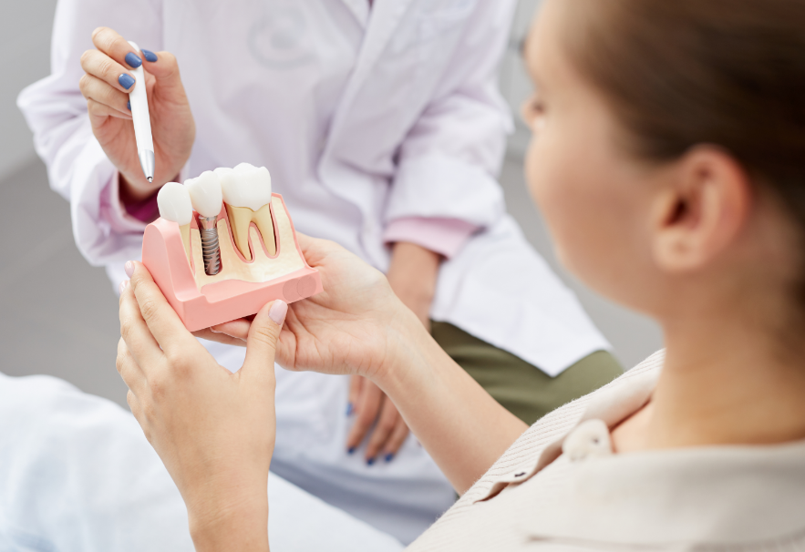 Dentist showing patient dental implant model